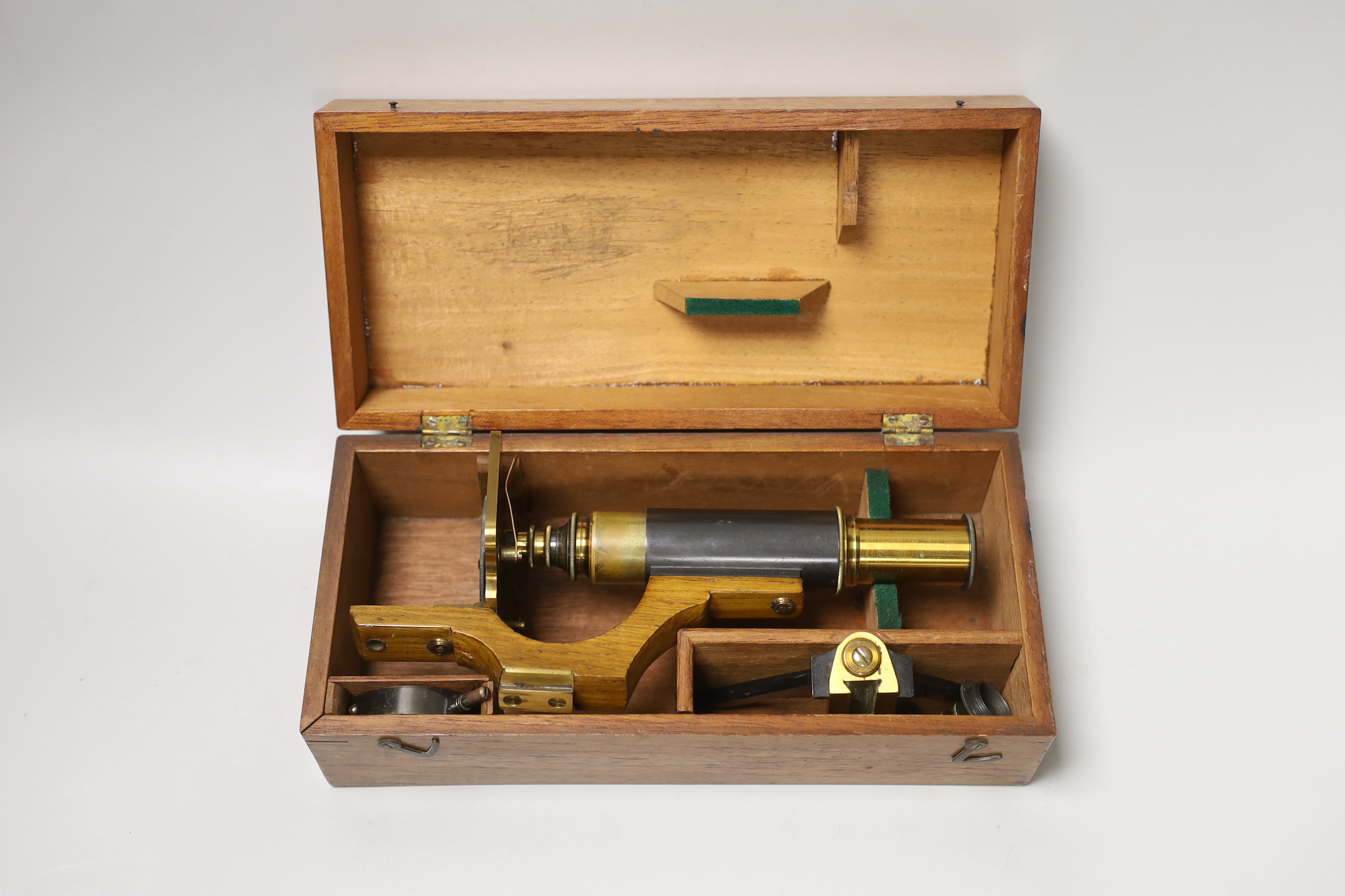 A lacquered brass field microscope, in fitted case, case 26cm wide